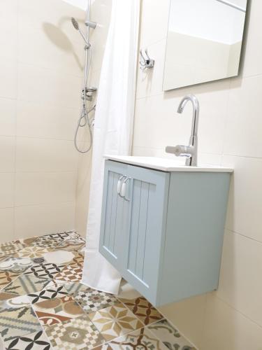 La salle de bains est pourvue d'un lavabo et d'une douche. dans l'établissement City Center Rooms, à Nazareth