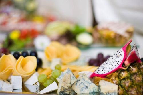 un plato de comida con queso, fruta y un cuchillo en Magnolia- Pokoje Gościnne, en Zgorzelec