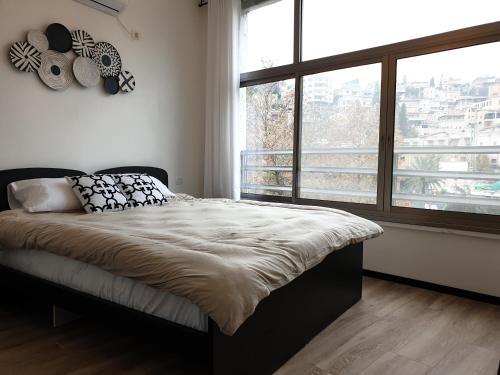 1 dormitorio con cama y ventana grande en City Center Rooms en Nazareth