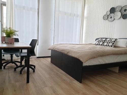 a bedroom with a bed and a desk and a table at City Center Rooms in Nazareth