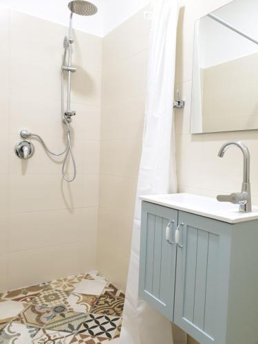 a bathroom with a sink and a shower with a mirror at City Center Rooms in Nazareth