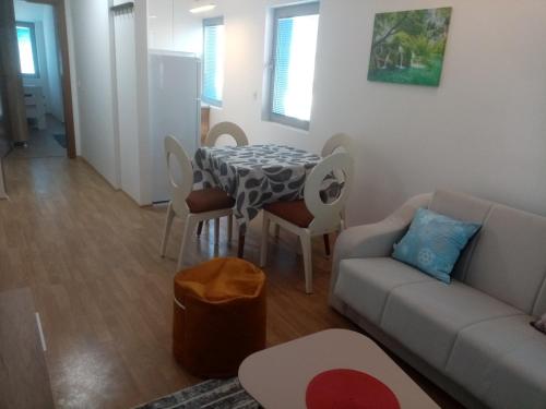 a living room with a couch and a table and chairs at FLAMANITA APARTMENTS in Skopje