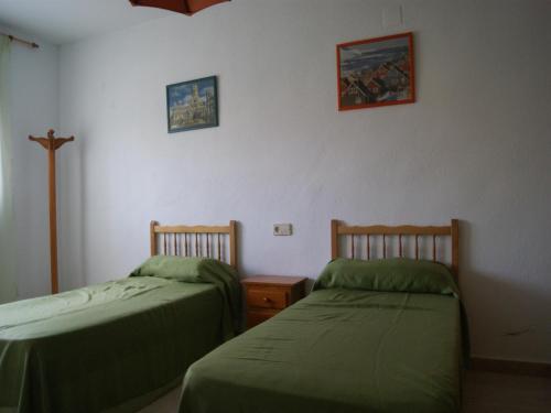 Habitación con 2 camas y una cruz en la pared. en Chalet San Antonio LEK, en Peñíscola