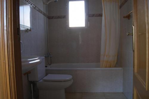 baño con aseo, bañera y ventana en Chalet San Antonio LEK, en Peñíscola