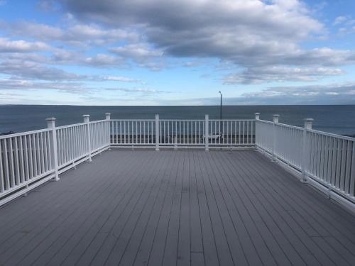 a white deck with the ocean in the background at The Atlantic House in Narragansett