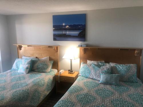 a hotel room with two beds and a lamp at The Atlantic House in Narragansett