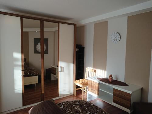 ein Wohnzimmer mit einem Schreibtisch und einer Uhr an der Wand in der Unterkunft Ferienwohnung Eichsfeld in Heilbad Heiligenstadt