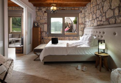a bedroom with a bed and a person in a window at Five Senses Luxury Villas in Vourvourou