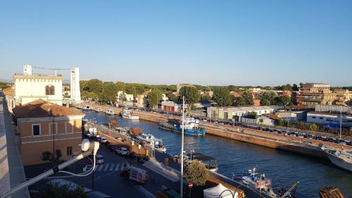 a river with boats docked in a city at la Dimora del Borgo in Fiumicino