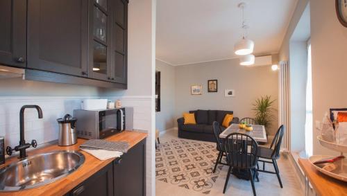 a kitchen with a sink and a living room at la Dimora del Borgo in Fiumicino