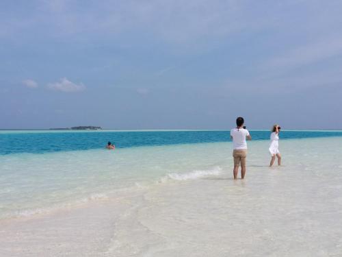 a man and a woman standing on the beach at Ras Rana Lodge in Rasdu