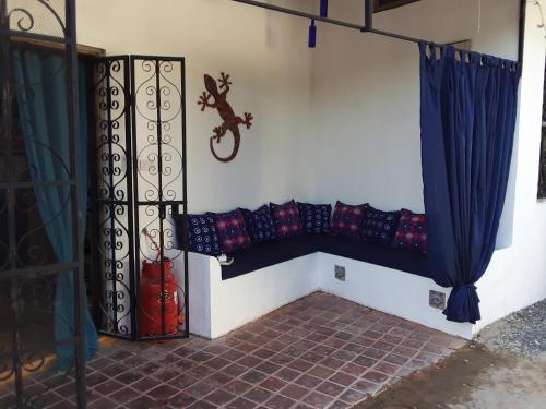 eine Zimmerecke mit einer Wand mit einer Bank in der Unterkunft Gecko Cottage in Bagamoyo