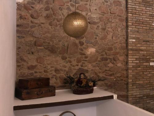 a room with a stone wall and aendant light at Beni Qásim 1915 in Benicàssim