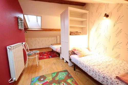 a small bedroom with two beds and a window at la grange aux créations in Mentières