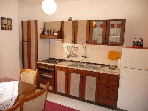 a kitchen with a sink and a refrigerator at Apartments Anica in Sobra