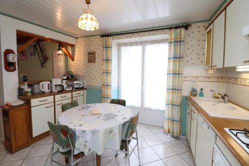 a kitchen with a table with a table cloth on it at la grange aux créations in Mentières
