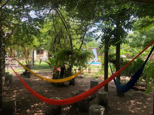 a group of hammocks hanging from trees in a park at Casa de Férias em Alter do Chão-PA in Alter do Chao