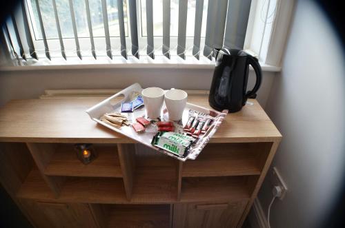 una mesa con dos tazas encima de una ventana en Gorton Mount Hotel Manchester, en Mánchester