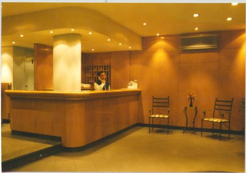 Ein Mann sitzt in einer Bar in einer Lobby. in der Unterkunft Hotel Eldorado in Salto