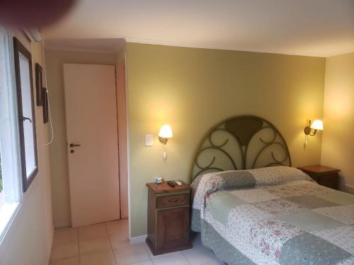 a bedroom with a bed and a table and a door at Casa los Tilos in Valeria del Mar