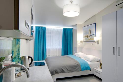 1 dormitorio con 1 cama con cortinas azules y lavamanos en Arena Apartments, en Kiev