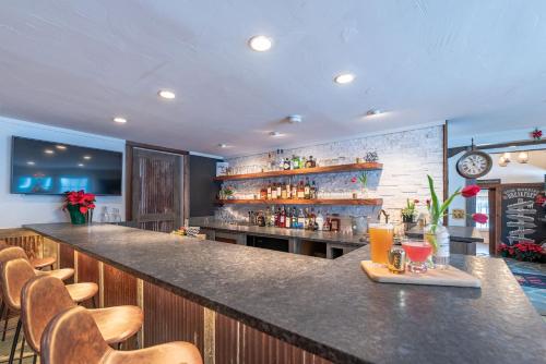 a bar in a restaurant with a counter and chairs at The Barnstead Inn in Manchester Center