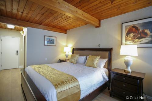 a bedroom with a bed and two lamps on tables at Grizz Hotel in Revelstoke