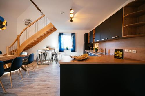 eine Küche und ein Esszimmer mit einer Treppe in einem Haus in der Unterkunft Ferienhaus Hünzingen № 2 in Walsrode