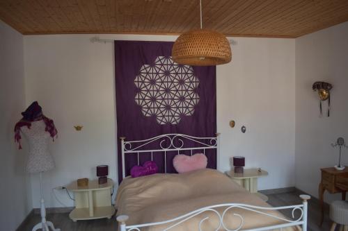 um quarto com uma cama e uma cortina roxa em BLEU Seize em Natzwiller