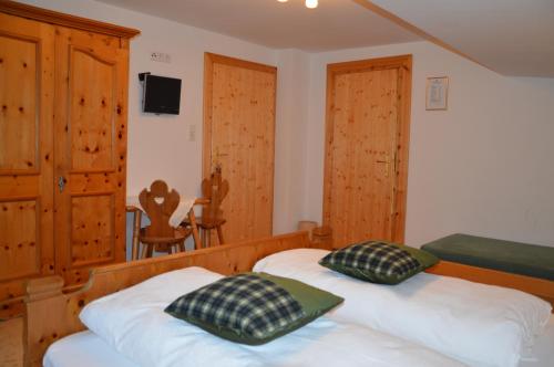 a bedroom with two beds and wooden cabinets and a table at Haus Salvenmoser in Walchsee