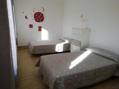 a room with two beds and a wall with stickers at Antigua escuela in Cañada Vellida