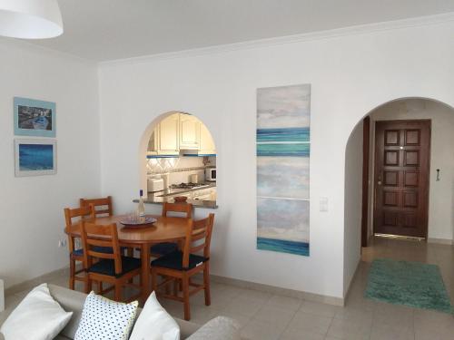 uma sala de jantar e cozinha com mesa e cadeiras em Amarguinha no Burgau