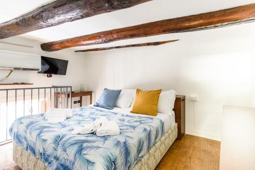 a bedroom with a large bed with blue and yellow pillows at RESIDENZA SANTA LUCIA in Naples