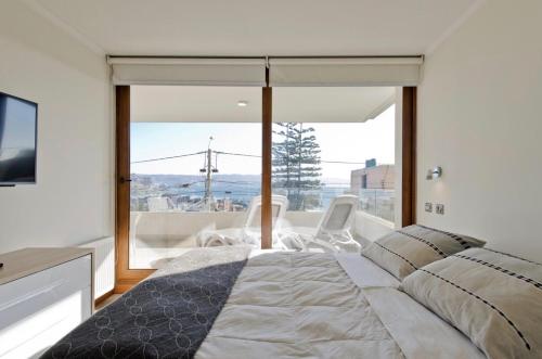 a bedroom with a bed and a large window at Reñaka Happy in Viña del Mar