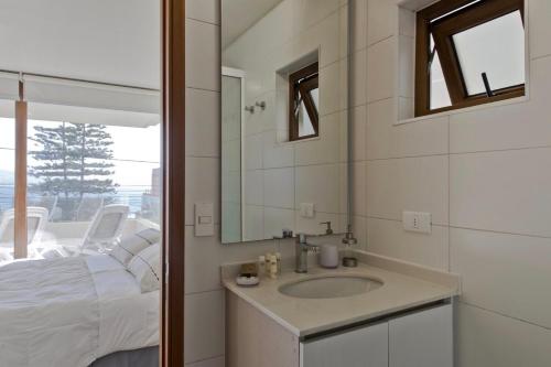baño con lavabo, cama y espejo en Reñaka Happy, en Viña del Mar