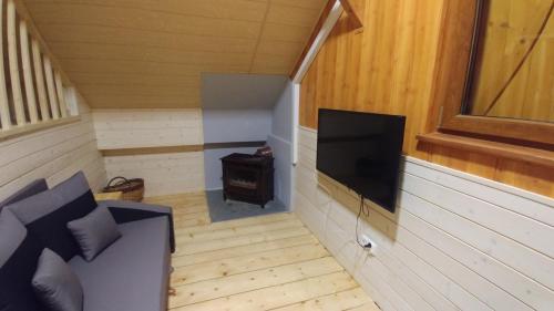 a small room with a television in a house at Sielanówek - Orzechowa Chatka z sauną wanną termalną jacuzzi in Żywiec