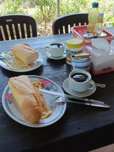 una mesa con platos de comida y tazas de café en SunRise Villa, en Kampong Cham