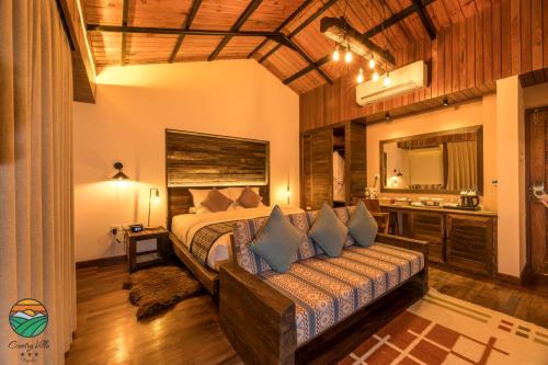 a bedroom with a bed and a couch in a room at Hotel Country Villa in Nagarkot