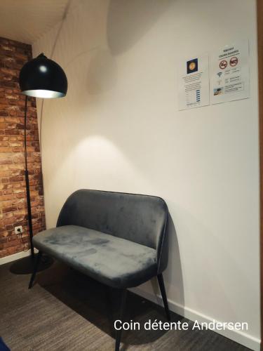 a chair sitting in a room next to a lamp at DayNight Sauveniere in Liège