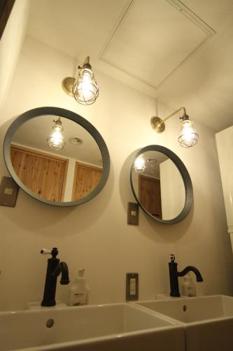 a bathroom with two mirrors and a sink at guesthouse SHIBAFU in Kamakura