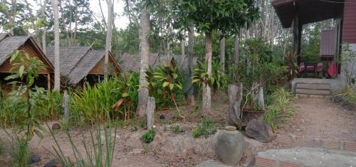 a garden with trees and plants and a house at Dahla Lanta Hut in Ko Lanta
