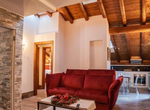 un soggiorno con divano rosso e tavolo di Residenza Marconi a Pinzolo