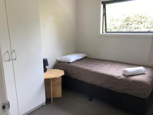 a small bedroom with a bed and a window at Geraldine TOP 10 Holiday Park in Geraldine