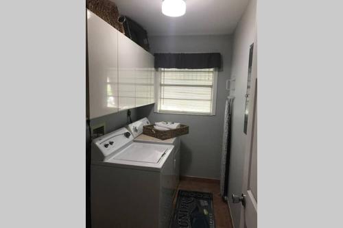 a small bathroom with a sink and a washing machine at Tranquility in Paradise - Cudjoe in Summerland Key