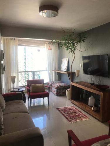 sala de estar con sofá y TV de pantalla plana en Apartamento com vista!, en Balneário Camboriú