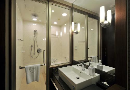 uma casa de banho com um lavatório e um chuveiro em The Royal Park Hotel Fukuoka em Fukuoka