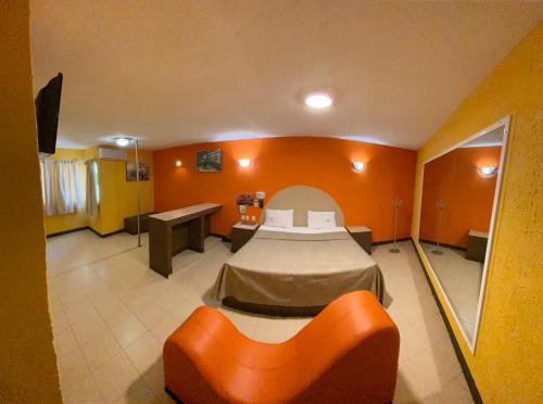 Habitación con cama y sofá. en Auto Hotel Villaferr, en Oaxaca City