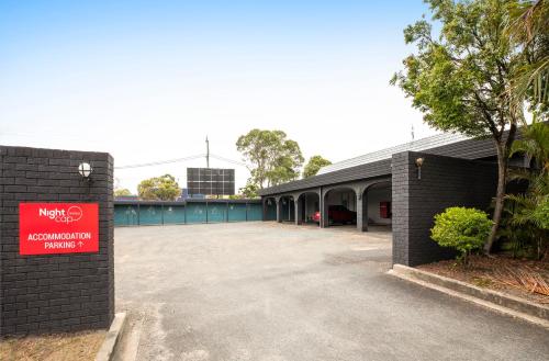 a building with a red sign on the side of it at Nightcap at Springwood Hotel in Springwood