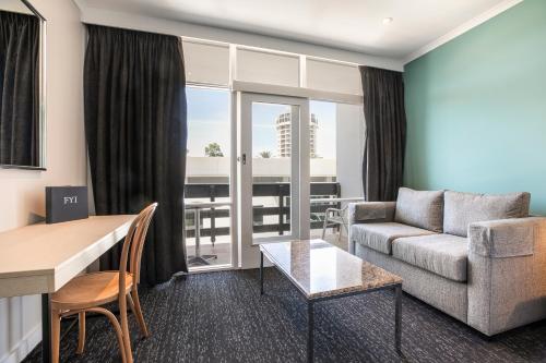 a living room with a couch and a table at Nightcap at Watermark Glenelg in Adelaide