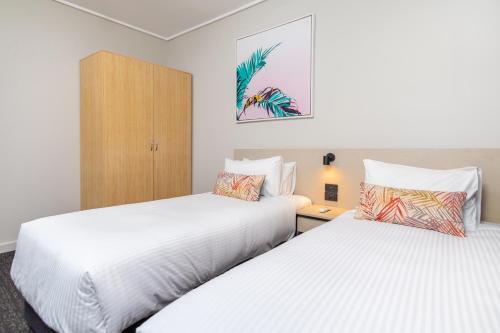 two beds in a hotel room with white sheets at Nightcap at Springwood Hotel in Springwood